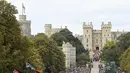 Para pelayat menyaksikan State Hearse of Queen Elizabeth II saat berkendara di sepanjang Long Walk menjelang Committal Service untuk Ratu Elizabeth II pada Senin, 19 September 2022 di Windsor, Inggris. (Stuart C. Wilson/Pool Photo via AP)