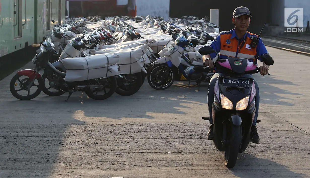 Petugas membawa sepeda motor untuk diangkut dengan kereta api Stasiun Kampung Bandan, Jakarta, Senin (11/6). Program mudik gratis ini digagas Kemenhub tersebut melayani pengiriman ke beberapa daerah di Pulau Jawa. (Liputan6.com/Immanuel Antonius)