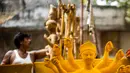 Seorang perajin membuat patung dewi Durga menjelang festival 'Durga Puja' di sebuah workshop di New Delhi, India, Rabu (14/10/2020). Durga Puja merupakan festival tahunan di Asia Selatan untuk memuja dewi Durga dari agama Hindu. (Photo by Jewel SAMAD / AFP)