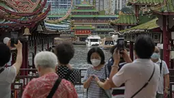 Turis mengambil foto Restoran Terapung Jumbo yang ikonik di Hong Kong, Senin (13/6/2022). Pemimpin Hong Kong Carrie Lam sebelumnya mengatakan bahwa pihak berwenang tidak akan menyelamatkan restoran, meskipun ada seruan dari anggota parlemen untuk melestarikan landmark ikonik tersebut. (AP Photo/Kin Cheung)