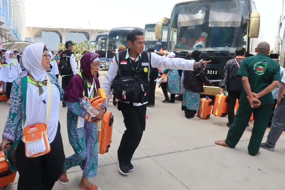 Petugas haji Indonesia mengarahkan jemaah haji ke bus. Foto: Darmawan/MCH