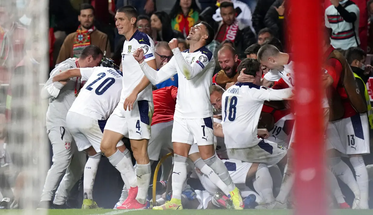 Pemain Serbia Aleksandar Mitrovic merayakan dengan rekan satu timnya usai mencetak gol ke gawang Portugal pada pertandingan kualifikasi Grup A Piala Dunia 2022 di Stadion Luz, Lisbon, 14 November 2021. Serbia menang 2-1. (AP Photo/Armando Franca)