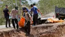 Petugas membawa jenazah korban gempa dan tsunami untuk dimakamkan massal di Palu, Sulawesi Tengah, Senin (1/10). (AP Photo/Tatan Syuflana)