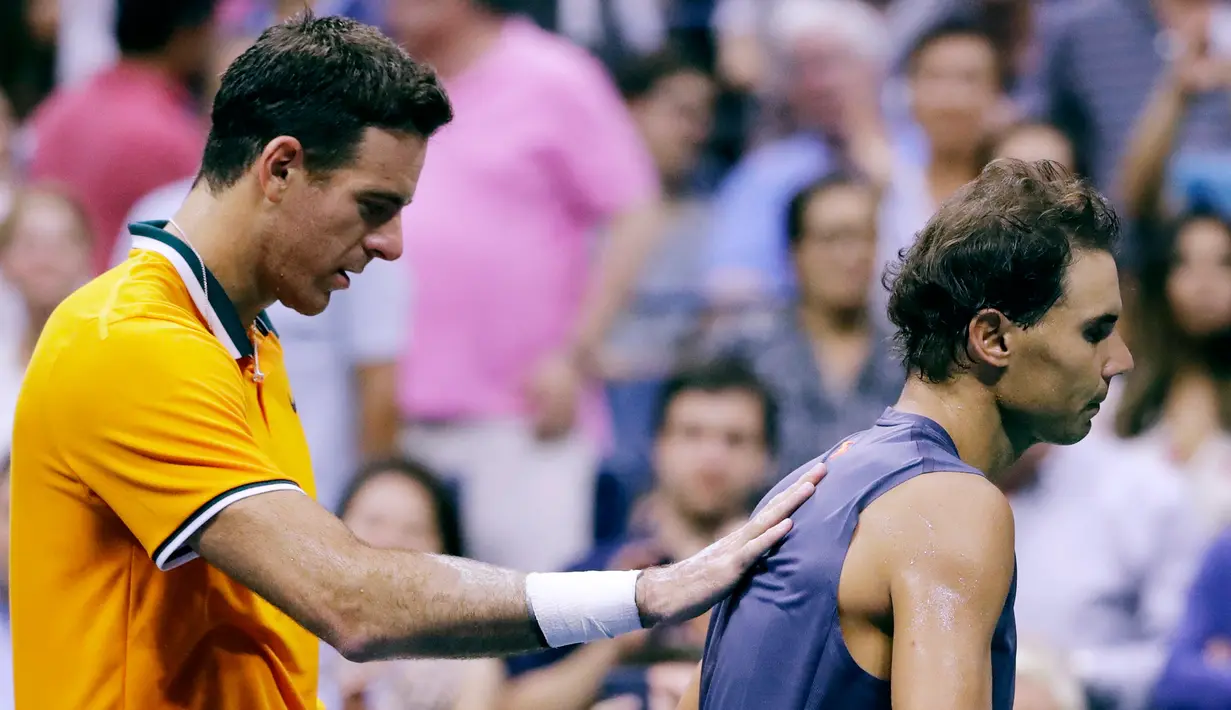 Petenis Spanyol, Rafael Nadal berjalan menjauh dari Juan Martin del Potro (Argentina) setelah mengundurkan diri pada semifinal AS Terbuka 2018, Jumat (7/9). Ini kedua kalinya pada tahun ini Nadal mengundurkan diri dari kejuaraan Grand Slam (AP/Seth Wenig)