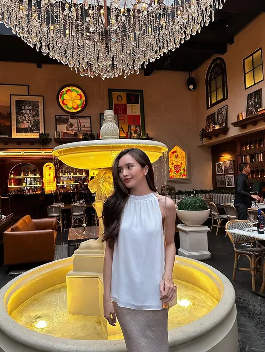 Padu padan blus putih dan rok satin warna gold bisa jadi inspirasi tampilan bukber non hijab yang elegan dari Beby Tsabina. [@bebytsabina]