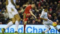 Pemain Liverpool, James Milner (tengah) melakukan tembakan melewati dua pemain Swansea City pada lanjutan Liga Premier Inggris antara Liverpool vs Swansea City di Stadion Anfiled, Senin (30/11/2015) dini hari WIB. (AFP Photo/Paul Ellis)