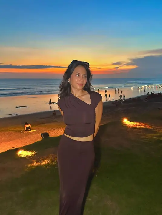 Menikmati matahari tenggelam di pantai, Pevita Pearce tampil cantik mengenakan atasan cropped top cokelat dengan bahu asimetris dan rok panjangnya yang serasi. [Foto: Instagram/pevpearce]