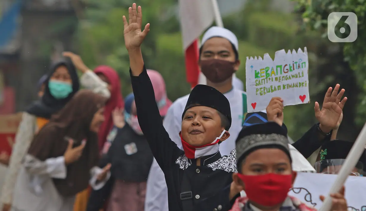 Sejumlah anak pengajian melakukan pawai di Jalan Raya Tapos, Depok, Jawa Barat, Kamis (22/10/2020). Pengajian Kampung Tapos menggelar pawai menyambut Hari Santri Nasional 2020 yang diperingati setiap tanggal 22 Oktober. (Liputan6.com/Herman Zakharia)