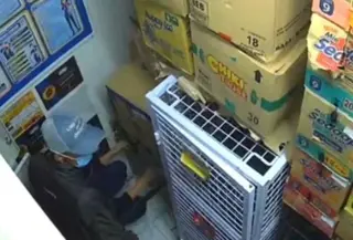 Salah satu pelaku perampokan menodongkan senjata api ke pegawai, sementara rekannya menggunakan golok. (Foto: Antara)