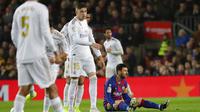 Striker Barcelona, Lionel Messi, terduduk lesu saat laga melawan Real Madrid pada laga La Liga 2019 di Stadion Camp Nou, Rabu (18/12). Kedua tim bermain imbang 0-0. (AP/Emilio Morenatti)