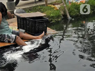 Warga mandi di Kali Cilemahabang yang menghitam di kawasan Karangbahagia, Kabupaten Bekasi, Jawa Barat, Selasa (7/9/2021). Warga memanfaatkan aliran Kali Cilemahabang yang menghitam dan mengeluarkan bau tak sedap untuk mencuci baju hingga mandi. (Liputan6.com/ Herman Zakharia)