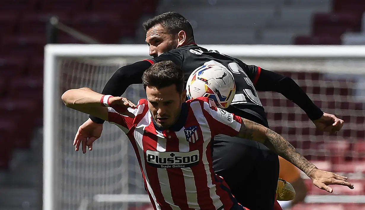 Gelandang Atletico Madrid, Saul (depan) berduel udara dengan bek Eibar, Anaitz Arbilla dalam laga lanjutan Liga Spanyol 2020/2021 pekan ke-31 di Wanda Metropolitano Stadium, Madrid, Minggu (18/4/2021). Atletico menang 5-0 atas Eibar. (AFP/Oscar del Pozo)