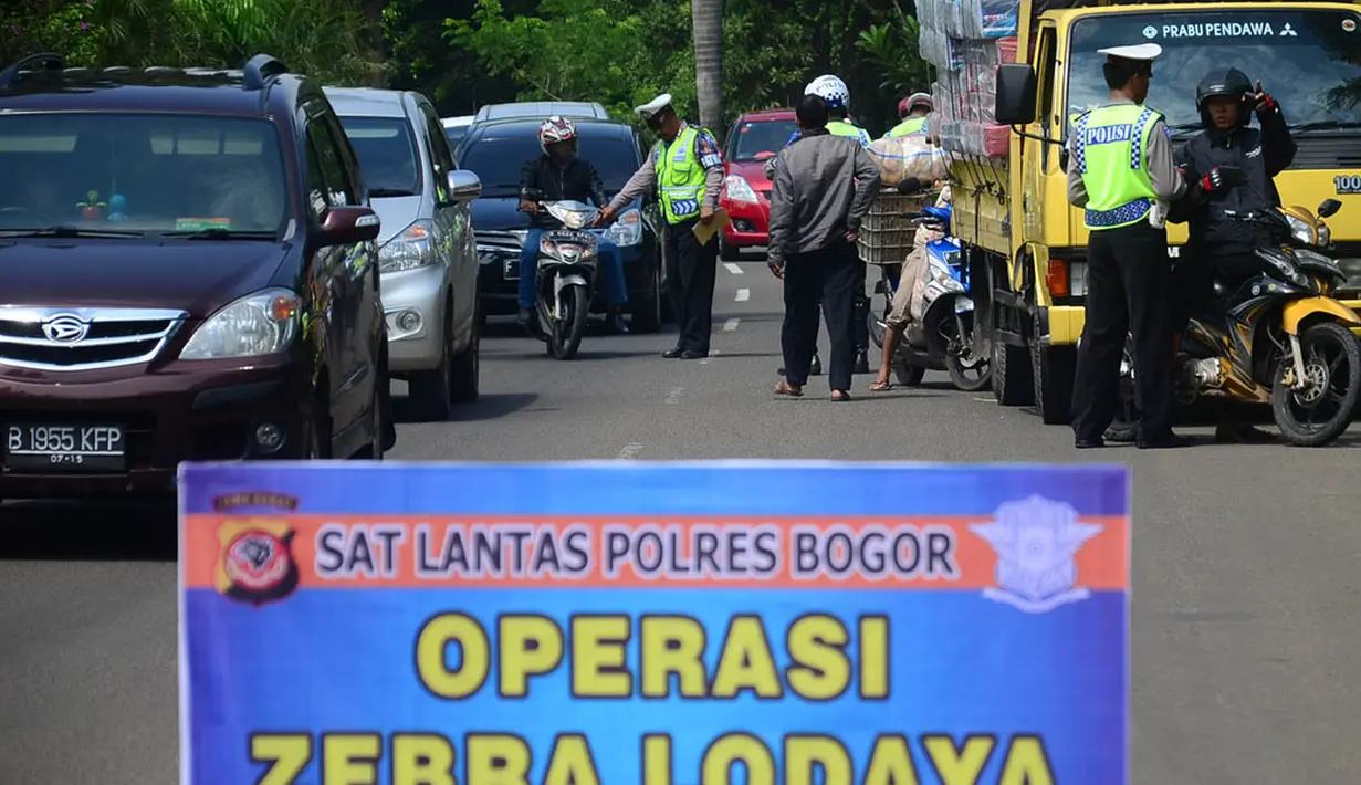Petugas Satuan Lalu Lintas (Satlantas) Polres Bogor memeriksa kelengkapan surat pengendara saat Operasi  Zebra Lodaya 2014 di Jalan Raya Tegar Beriman, Cibinong, Bogor, Jabar, Rabu (26/11). (ANTARA FOTO/Jafkhairi)
