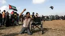Seorang pria Palestina bernama Saber al-Ashkar melemparkan batu saat bentrokan dengan pasukan Israel di jalur Gaza (11/5). Meski tidak memiliki kaki, Saber turut ikut bertempur melawan pasukan Israel. (AFP/Mahmud Hams)