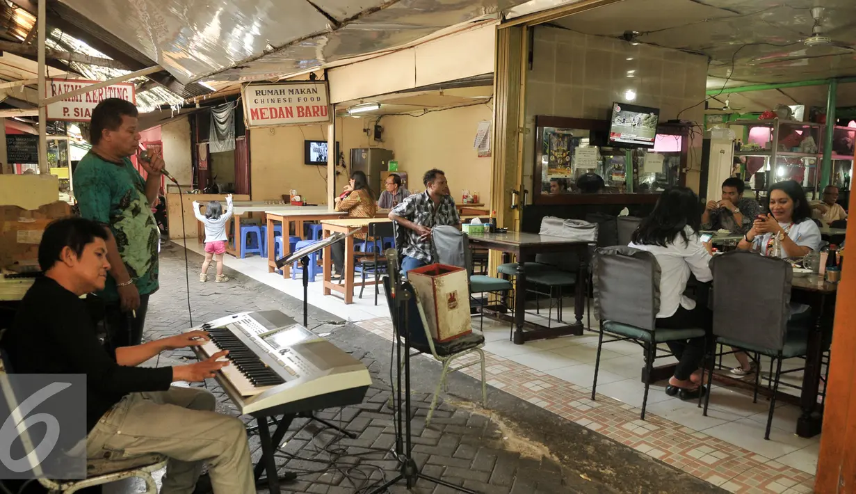 Seorang pria bernyanyi dengan iringan organ tunggal saat menghibur pengunjung di lapo kawasan kuliner khas daerah, Senayan, Jakarta, Rabu (18/1). Penutupan itu karena akan dibangun fasilitas penunjang kegiatan Asian Games 2018. (Liputan6.com/Yoppy Renato)