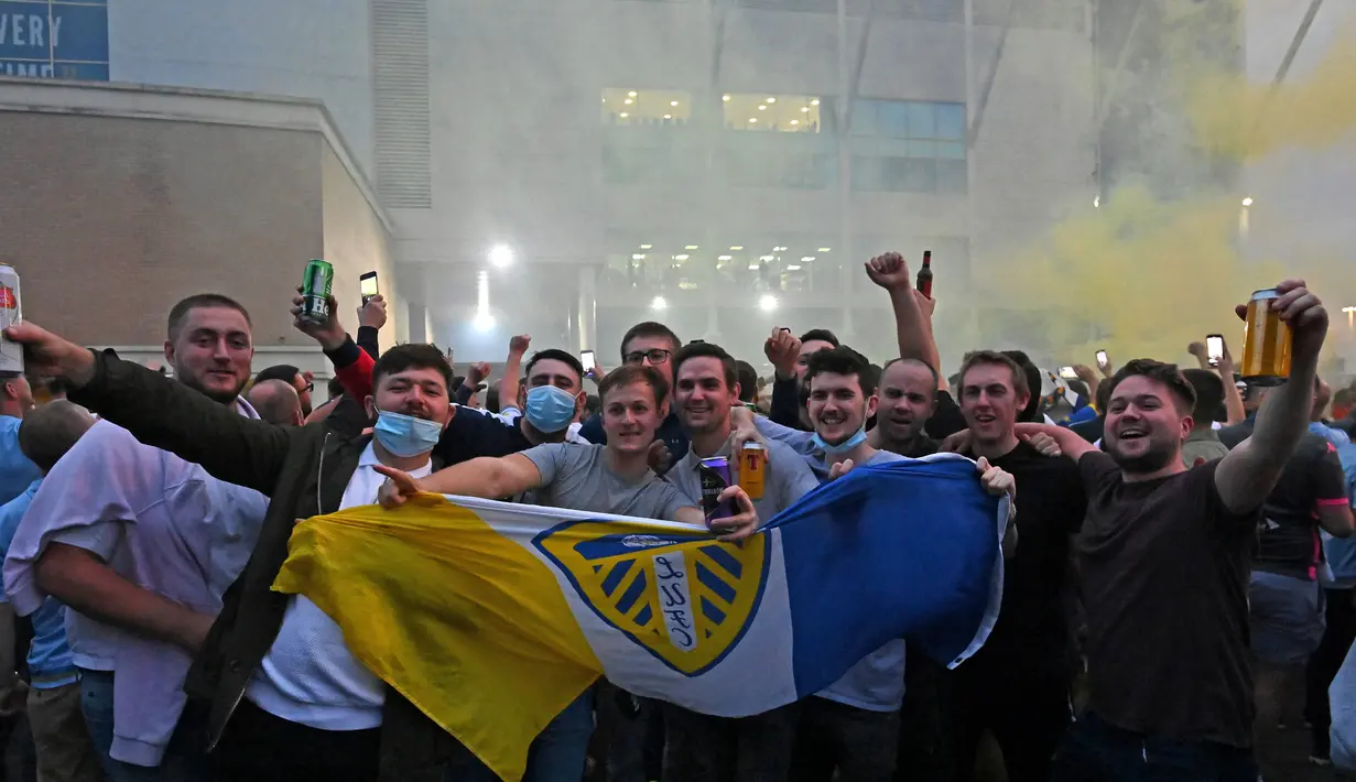 Pendukung Leeds United berkumpul di luar Elland Road merayakan kembalinya klub ke Liga Premier  di Leeds, Inggris (17/7/2020). Leeds berhasil menyegel satu tiket promosi setelah salah satu rivalnya di divisi Championship, West Bromwich Albion kalah 1-2 di kandang Huddersfield Town. (AFP/Paul Ellis)