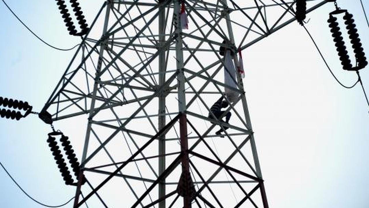 Pria berpakaian pocong di atas tower SUTET