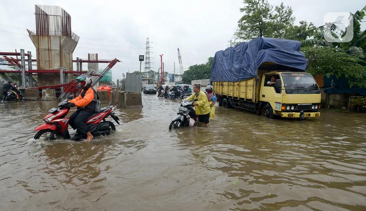 Sejumlah kendaraan bermotor melintasi banjir di Jalan Raya Bekasi, Jakarta Timur, Selasa (25/2/2020). Banjir akibat hujan yang melanda Bekasi sejak Selasa (25/2) dini hari memutus beberapa titik jalan raya di wilayah setempat. (merdeka.com/Imam Buhori)