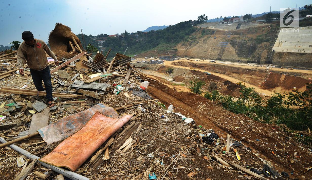 Warga berjalan melintasi puing-puing rumah yang terkena proyek pembangunan Bendungan Ciawi di Desa Gadog, Bogor, Jawa Barat, Kamis (22/08/2019). Bendungan Ciawi memiliki luas 31,96 hektare. (Merdeka.com/Arie Basuki)