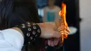 Penata rambut, Alberto Olmedo membakar ujung rambut pelanggannya di Madrid, Spanyol, 29 Desember 2018. Pria tersebut memilih menggunakan pedang samurai, api dan cakar besi untuk mewujudkan gaya rambut impian pelanggan. (AP/Manu Fernandez)