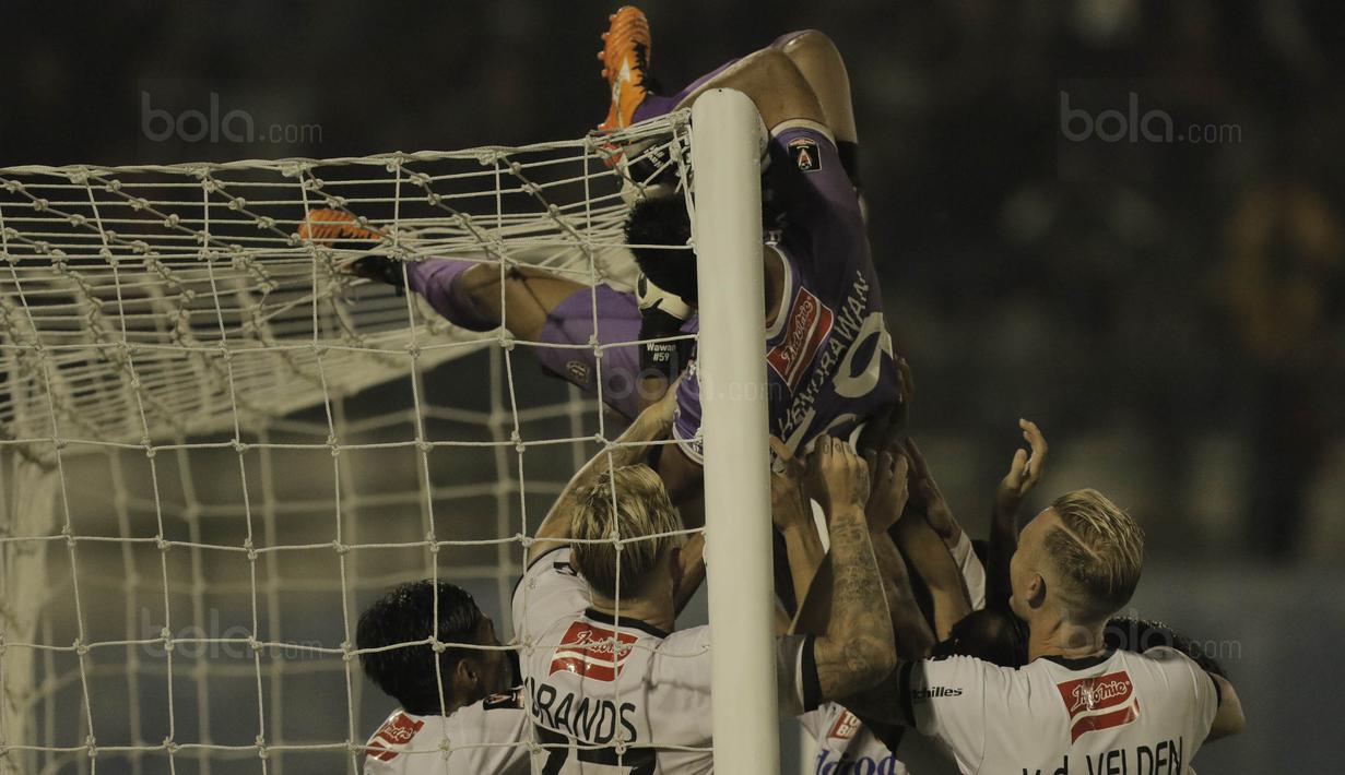 Kiper Bali United, Wawan Hendrawan, melakukan selebrasi panjat tiang gawang usai mengalahkan Madura United pada laga Piala Presiden di Stadion Manahan, Solo, Sabtu, (3/2/2018). Bali United menang adu penalti dengan skor 5-4. (Bola.com/M Iqbal Ichsan)