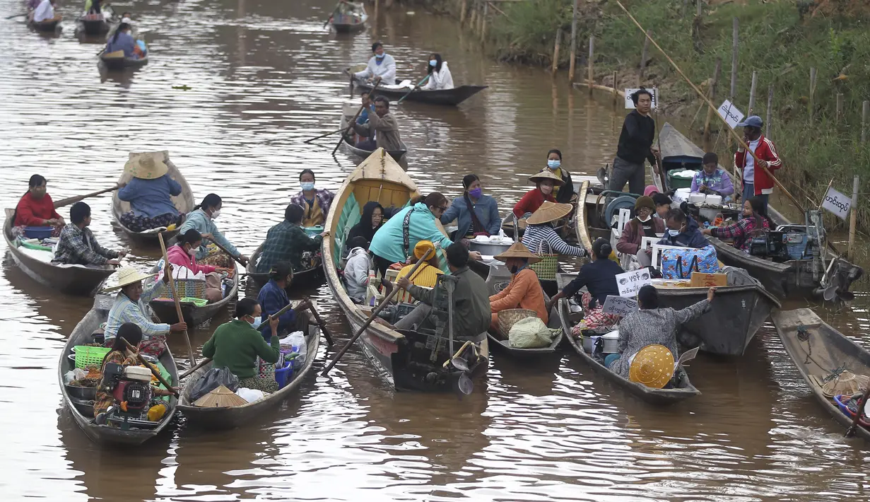 Penjual di atas kapal menjual makanan kepada pengunjung di pasar terapung lokal di Danau Inle yang terkenal, Negara Bagian Shan selatan, Myanmar,  Sabtu (15/1/2022). Ada sekitar 70 ribu jiwa populasi masyarakat Intha yang hidup di sepanjang aliran Danau Inle. (AP Photo)