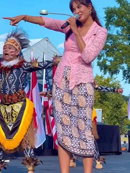 Ia mengenakan kebaya brokat klasik berwarna pink, dipadu kain batik abu-abu dengan sedikit sentuhan warna kuning sebagai rok yang dililitkan midi. [Foto: Instagram/aurelie]