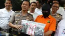 Kabid Humas Polda Metro Jaya Kombes Awi Setiyono memperlihatkan barang bukti beserta tersangka kasus videotron porno di Prapanca, Kebayoran Baru, berinisal SAR, saat rilis kasus videotron di Polda Metro Jaya, Rabu (5/10). (Liputan6.com/Immanuel Antonius)