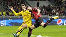 Olivier Giroud dari AC Milan, kanan, berebut bola dengan pemain Dortmund Nico Schlotterbeck pada pertandingan sepak bola grup F Liga Champions antara AC Milan dan Borussia Dortmund di stadion San Siro di Milan, Italia, Selasa, 28 November 2023. (AP Photo /Antonio Calanni)