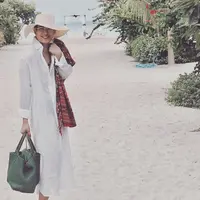 Oscar Lawalata yang sudah mengganti namanya Asha Smara Darra punya gaya simple dan stylish saat liburan di pantai. Seperti tunik kerah kemeja dengan topi lebar, syar warna cerah, serta totebag. (Foto: Instagram/oscarlawalata)