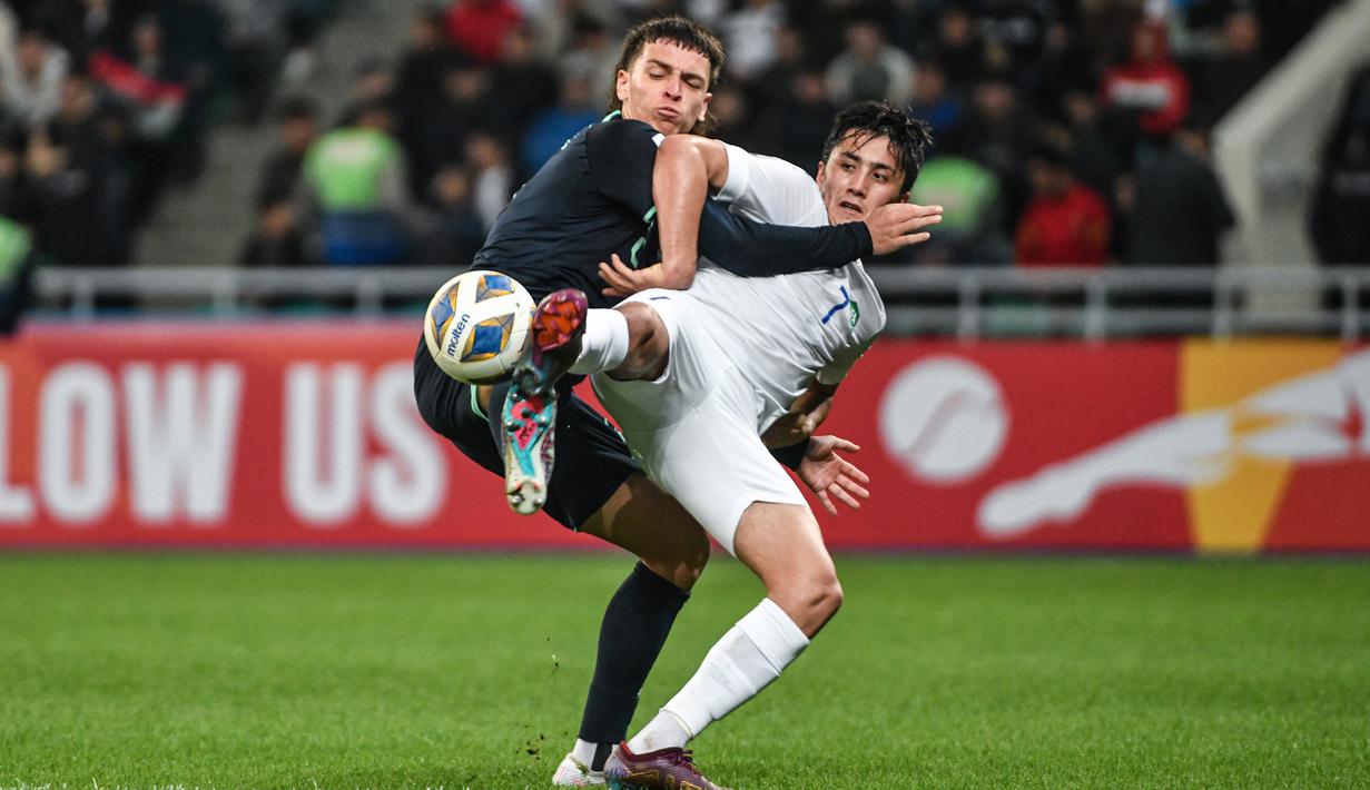 Pemain Uzbekistan U-20, Pulatkhuja Kholdorkhonov (kanan) berebut bola dengan pemain Australia U-20, Joshua Rawlins pada laga perempatfinal Piala Asia U-20 2023 di Milliy Stadium, Tashkent, Uzbekistan, Sabtu (11/3/2023). (AFC/Hasan Pirmuhamedov)