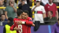 Bruno Fernandes dari Portugal melakukan selebrasi bersamaCristiano Ronaldo setelah mencetak gol ketiga timnya pada pertandingan Grup F antara Turki dan Portugal pada turnamen sepak bola Euro 2024 di Dortmund, Jerman, Sabtu, 22 Juni 2024. (AP Photo/Darko Vojinovic)