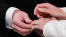 Jack Brooksbank memasang cincin di jari Putri Eugenie saat upacara pernikahan mereka di Kapel St. George, Windsor Castle, London, Inggris,  Jumat (12/10). Ada 850 orang penting yang masuk ke daftar utama tamu undangan. (Danny Lawson/Pool via AP)
