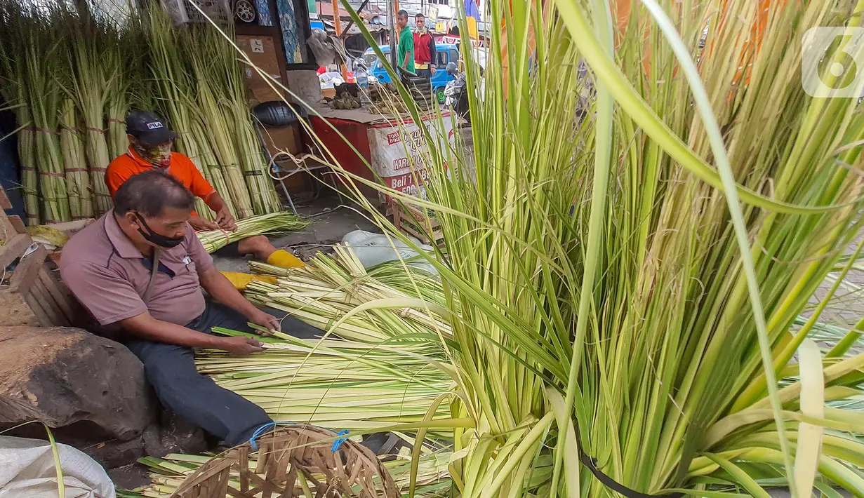 Pedagang membuat kulit ketupat dari anyaman daun kelapa muda (janur) di Pasar Pondok Labu, Jakarta Selatan, Kamis (30/7/2020). Memasuki Hari Raya Idul Adha ketupat yang merupakan hidangan khas Asia Tenggara dengan bahan dasar beras disajikan pada saat Hari Raya. (Liputan6.com/Fery Pradolo)