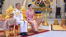 Raja Maha Vajiralongkorn (kiri) duduk bersama Ratu Suthida saat melangsungkan prosesi pernikahan mereka di Bangkok, Thailand, Rabu (1/5/2019). Ratu Suthida cukup lama menjadi pengawal pribadi Raja Maha Vajiralongkorn dan sering menghadiri acara publik bersama. (Thai TV Pool via Reuters)