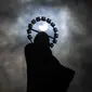 Siluet Patung Our Lady, Star Of The Sea saat gerhana matahari parsial di langit di Bull Wall, Dublin, Kamis (10/6/2021). Fenomena gerhana matahari cincin memperlihatkan bulan tidak sepenuhnya menutup seluruh bagian matahari sehingga bagian pinggir bulan terlihat bercahaya. (Brian Lawless/PA via AP)