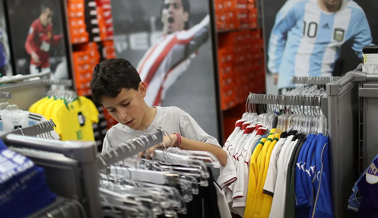 Matthias Meyer memilih jersey timnas Jerman di toko Soccer Locker, Florida, Rabu (13/6). Suporter sudah meramaikan pusat perbelanjaan untuk mendukung timnas Jerman yang akan berlaga di Piala Dunia 2018 Rusia. (Joe Raedle/Getty Images/AFP)