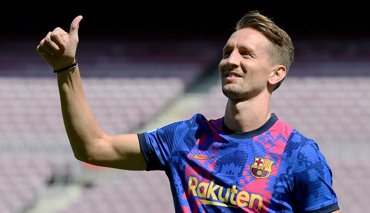 Pesepak bola asal Belanda Luuk de Jong berpose untuk para wartawan foto saat diperkenalkan sebagai rekrutan baru Barcelona, di stadion Camp Nou di Barcelona, Kamis (9/9/2021). De Jong merupakan pemain yang dimiliki Sevilla sebelum bergabung bersama Barcelona. (Josep LAGO / AFP)
