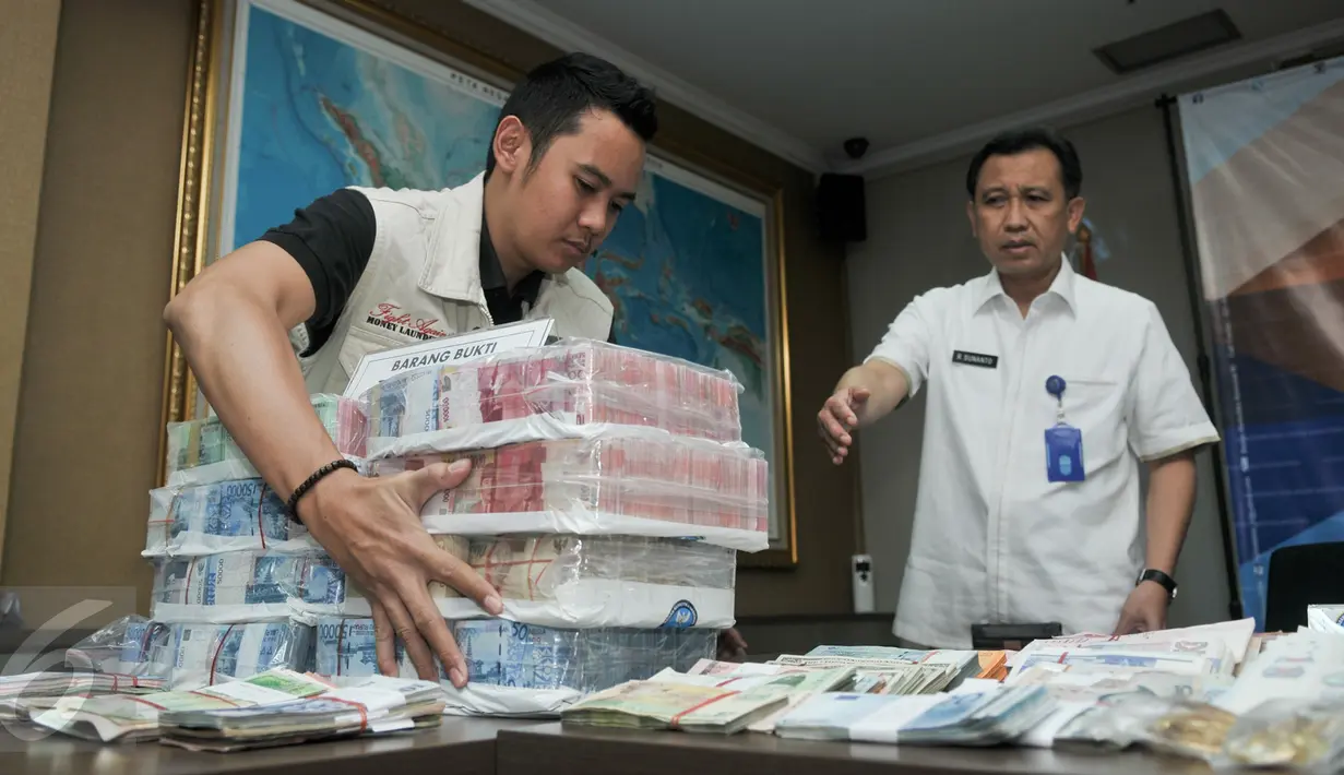 Petugas menata barang bukti kasus transaksi keuangan hasil kejahatan narkotika di Gedung BNN, Jakarta, Selasa (25/10). BNN mengungkap Tindak Pidana Pencucian Uang (TPPU) selama setahun terakhir senilai Rp2,7 triliun. (Liputan6.com/Yoppy Renato)