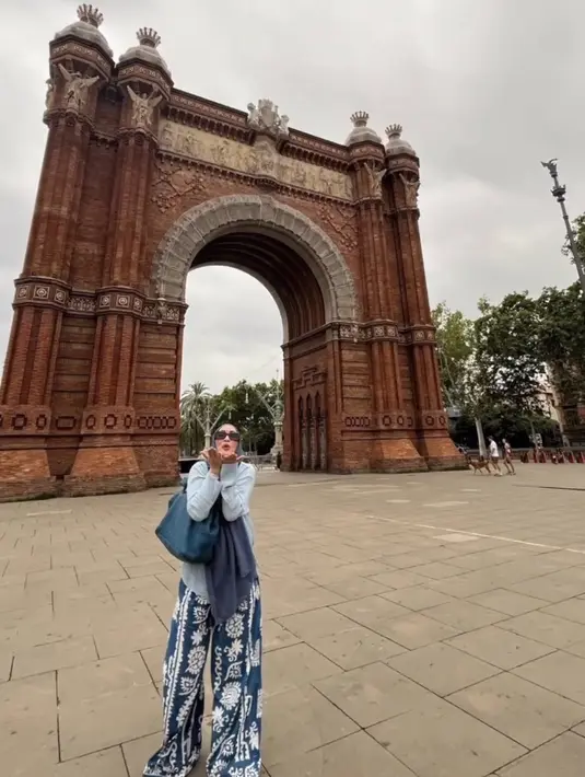 Ibu sambung Aaliyah Massaid ini juga tampil mengenakan atasan putih lengan panjang dipadukan kerudung panjang navy senada dengan celana bermotif dan shoulder bagnya. [@angelinasondakh09]