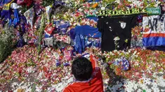Seorang pria melakukan tabur bunga di luar Stadion Kanjuruhan, Malang, Jawa Timur, Selasa (4/10/2022). Polri menjatuhkan sanksi kepada 10 anggota polisi dan menyelidiki 18 orang lainnya buntut tragedi kerusuhan yang menewaskan 125 orang di Stadion Kanjuruhan. (AP Photo/Dicky Bisinglasi)