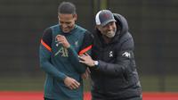 Bek Liverpool Virgil van Dijk berbicara dengan sang pelatih Liverpool Jurgen Klopp selama hari media dan sesi latihan di pusat pelatihan di Liverpool, Inggris, Rabu (25/6/2022). Liverpool mengusung misi balas dendam saat menghadapi Real Madrid di final Liga Champions di Parc des Princes, Paris pada Minggu, 29 Mei 2022 dini hari WIB. (AP Photo/Jon Super)