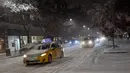 Mobil-mobil melaju saat salju mulai turun di Manhattan, New York, Kamis (15/11). Layanan Cuaca Nasional memprediksi hujan salju pertama pada awal musim dingin itu akan mencapai ketebalan 2-4 inci. (Angela Weiss / AFP)