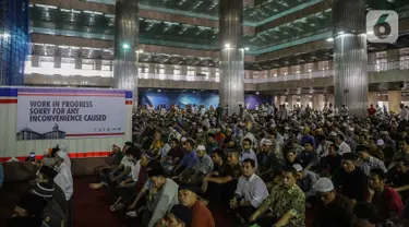 Jemaah mendengarkan ceramah saat melaksanakan salat Jumat di samping renovasi Mesjid Istiqlal, Jakarta, Jumat (1/11/2019). Renovasi ditargetkan rampung pada Maret 2020 sehingga dapat dimanfaatkan pada Bulan Ramadan tahun depan. (Liputan6.com/Faizal Fanani)