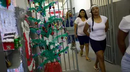 Narapidana wanita meninggalkan sel mereka untuk mengikuti perayaan Natal di Penjara Nelson Hungria, Rio de Janeiro, Brasil, Kamis (13/12). Acara ini dilakukan setiap tahun. (AP Photo/Silvia Izquierdo)