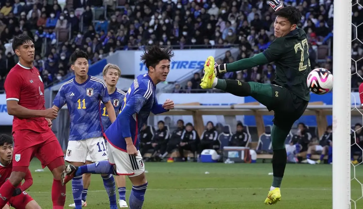 Pemain Jepang, Takumu Kawamura, mencetak gol ke gawang Thailand pada laga uji coba di Stadion Nasional Jepang, Tokyo, Senin (1/1/2023). (AP Photo/Shuji Kajiyama)