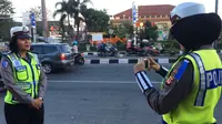 Di tengah lalu lalang pemudik, dua polwan dari Polresta Cirebon sibuk melakukan live report atau laporan langsung yang diunggah melalui media sosial. (Liputan6.com/Panji Prayitno)