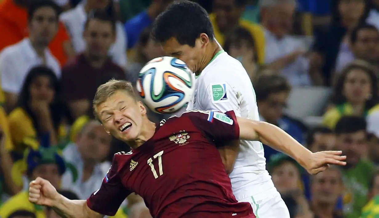Gelandang Timnas Rusia, Oleg Shatov (kiri) berebut bola atas dengan pemain Aljazair, Aissa Mandi, di laga penyisihan Piala Dunia Grup H di Stadion Baixada, Curitiba, Brasil, (27/6/2014). (REUTERS/Murad Sezer) 
