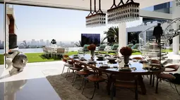 Suasana ruang makan di dalam dan luar ruangan di kawasan Bel-Air, Los Angeles,AS (26/1). Rumah ini memiliki ruang spa dan kolam renang dengan pemandangan kota Los Angeles. (AP/Jae C. Hong)