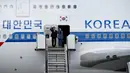 Presiden Korea Selatan, Moon Jae-in dan istrinya, Kim Jung-sook, melambaikan tangan setibanya di Hamburg, Jerman, Kamis (6/7). Sejumlah kepala negara telah tiba di Hamburg jelang pembukaan KTT G20 pada 7-8 Juli 2017. (Carsten Rehder / dpa via AP)